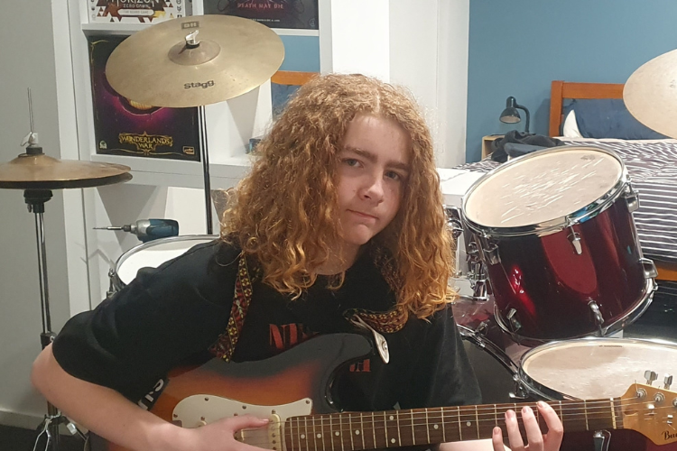 Photo of Luke holding his guitar